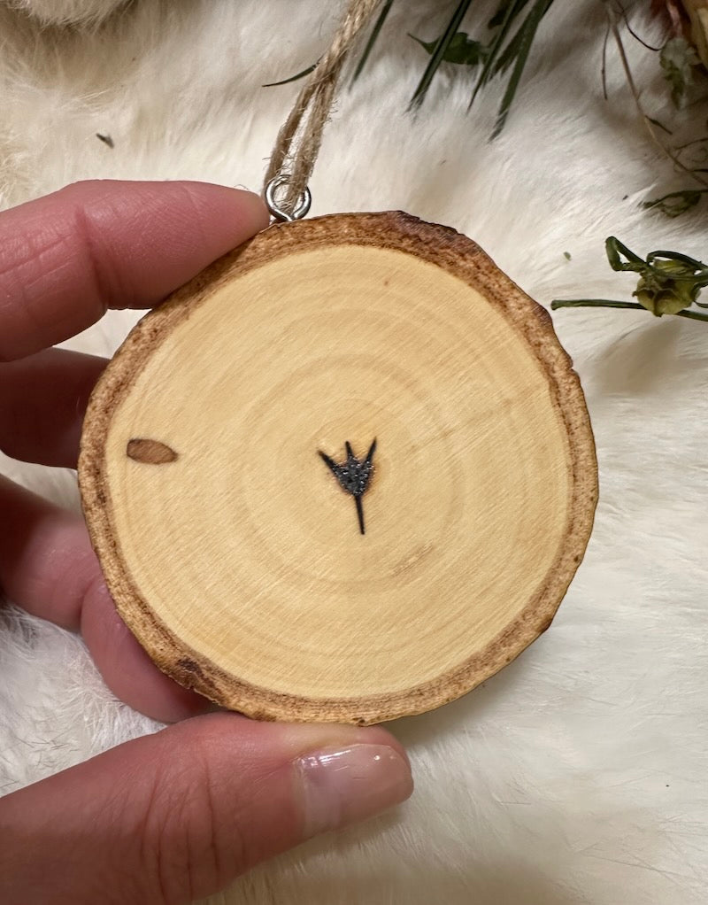 Wooden ornament with a small black object on a white surface